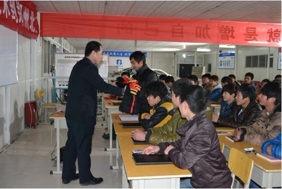 校长刘振华在开班仪式上为北方新学员发放北方校服
